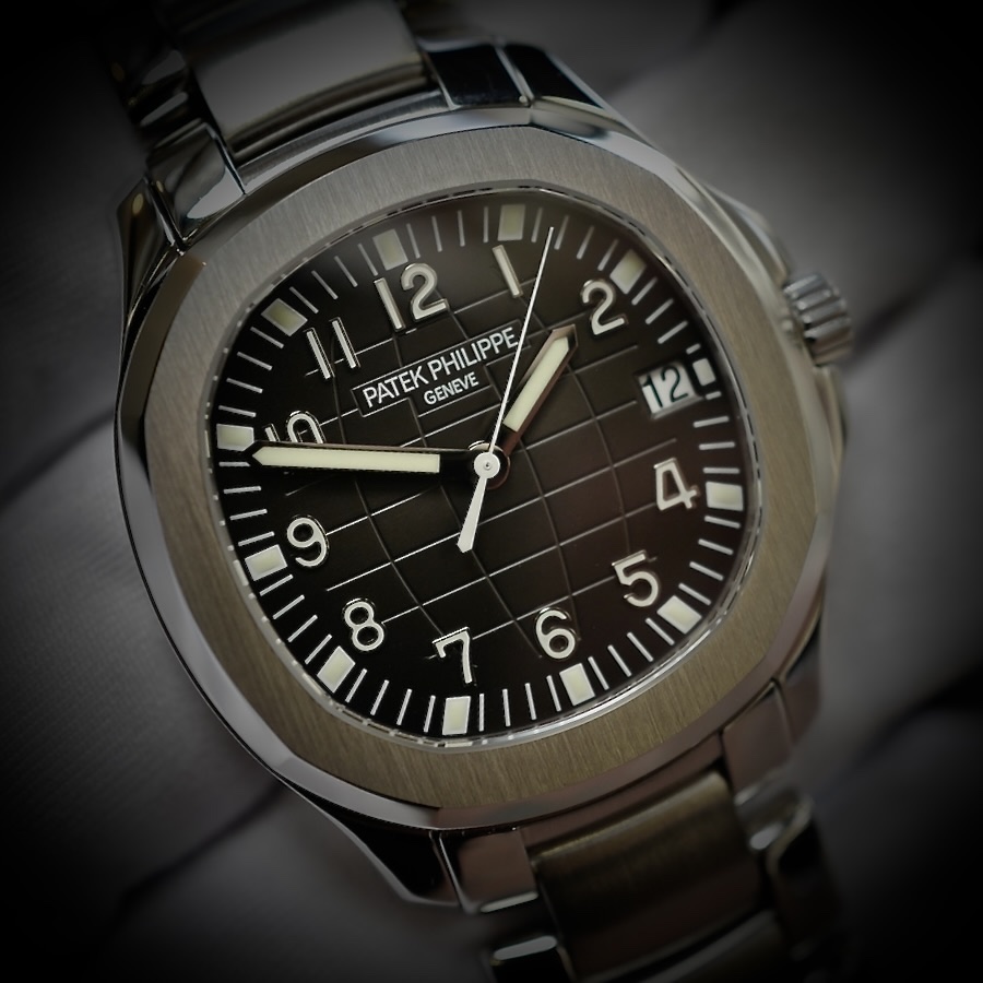 Close-up of a Patek Philippe stainless-steel luxury watch with a dark dial